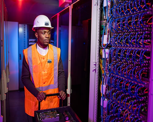 Data center electrician pushing cart with tools