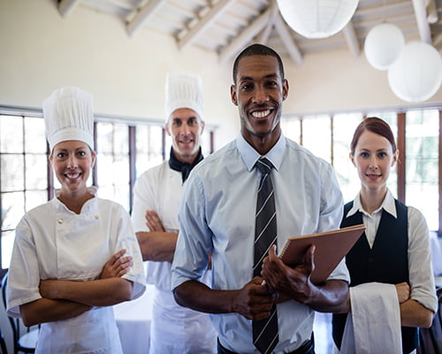 Group of happy hotel staffs standing in hotel
